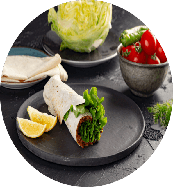 Marul, limon ve domates eşliğinde servis edilen Adıyaman çiğ köfte tabağı